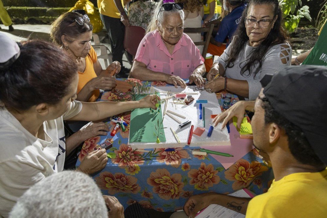 Moradores construindo juntos a maquete de um sonho para o bairro