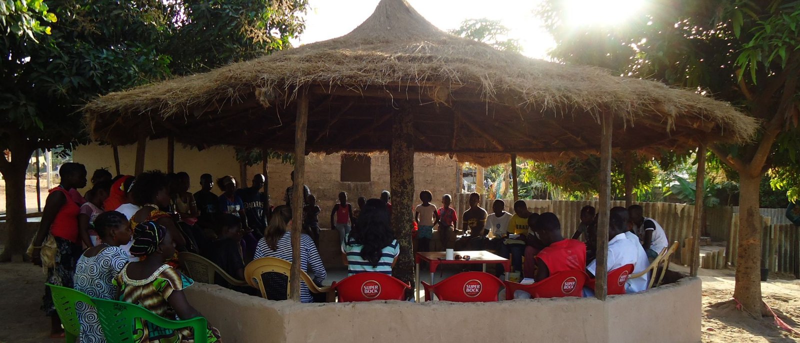 Assembleia comunitária sob um pavilhão redondo de palha, construído pela própria comunidade.